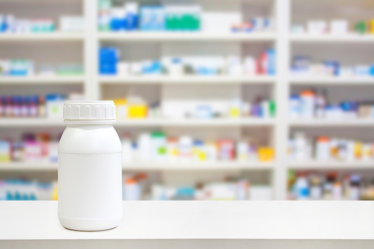 White pill bottle on a pharmacy counter