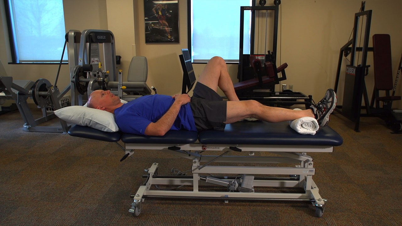 Patient on physical therapy table about to begin exercises. 